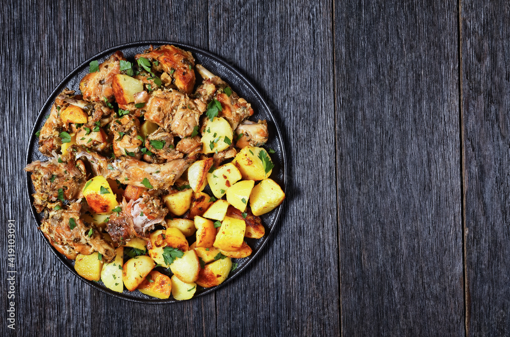 braised Rabbit with potatoes on a black plate braised Rabbit with potatoes on a black plate