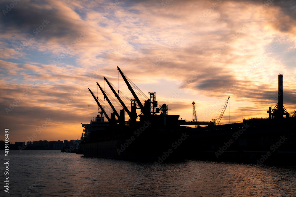 silhouette of a ship standing in the port against the background of the evening sky
