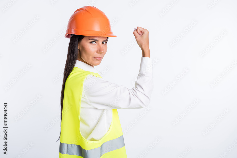 Photo of strong serious lady raise arm show biceps look camera wear helmet shirt vest isolated white color background