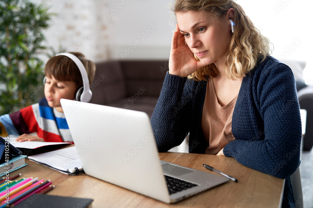 Frustrated mother during home office with her son at home Frustrated mother during home office with her son at home