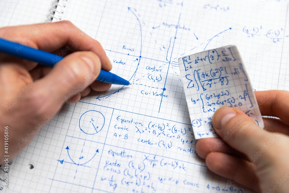 Man writing math exersize in notebook closeup