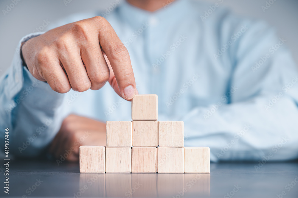 Businessman wearing a blue shirt, arranging the empty wooden blocks with his hands. Which is placed on a white wooden table. Business strategy and action plan. Copy space. Businessman wearing a blue shirt, arranging the empty wooden blocks with his hands. Which is placed on a white wooden table. Business strategy and action plan. Copy space.