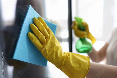 Man washing window in protective gloves closeup. Cleaning of apartments concept