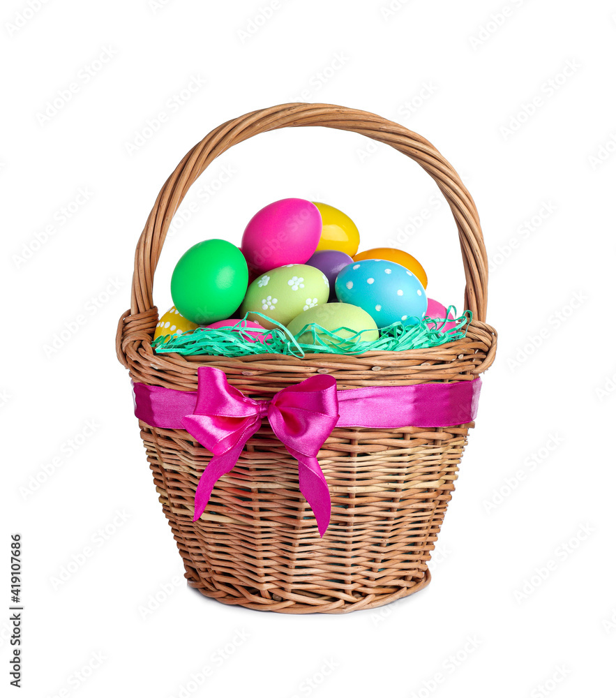 Naklejka premium Wicker basket with bright painted Easter eggs on white background