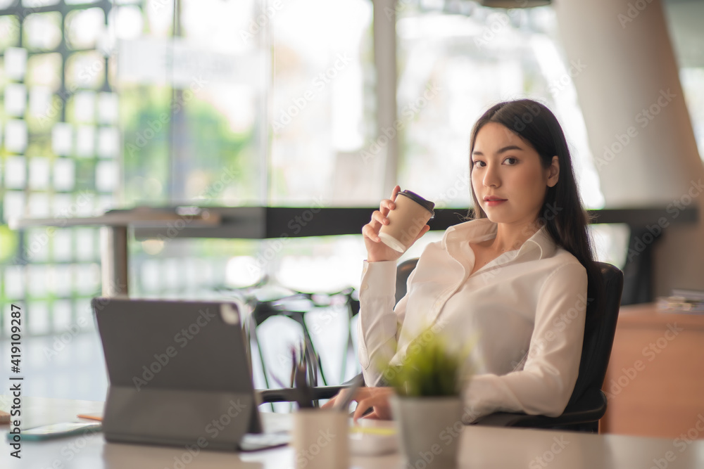 Obraz premium Businesswoman having tea or coffee in home office.