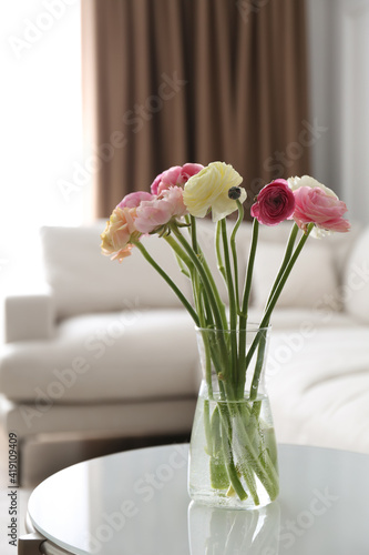 Beautiful ranunculus flowers on table in living room