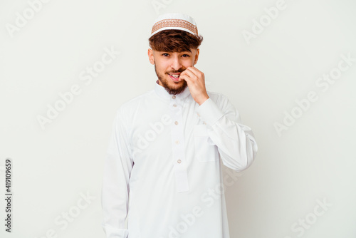 Young Arab man wearing the typical arabic costume isolated on white background biting fingernails, nervous and very anxious.