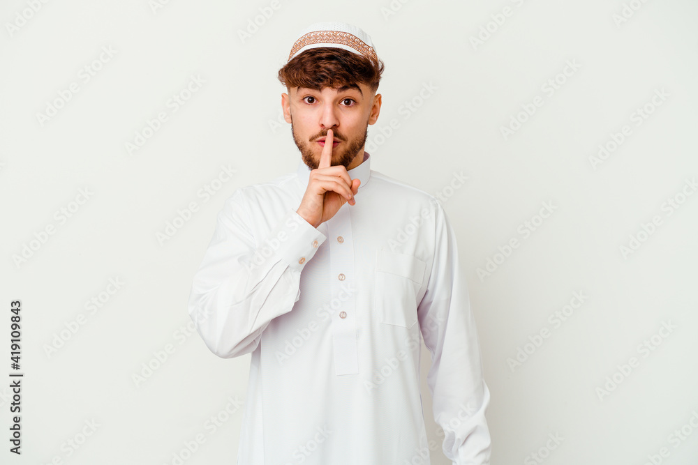 Young Arab man wearing the typical arabic costume isolated on white background keeping a secret or asking for silence. Young Arab man wearing the typical arabic costume isolated on white background keeping a secret or asking for silence.