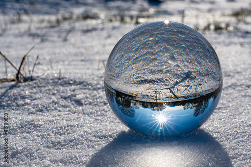 This lens ball shows the snowy meadow upside down during a sunny winter day in Zoetermeer