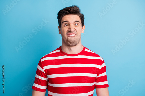 Photo portrait of silly comic man grimacing fooling in striped t-shirt isolated on bright blue color background photo