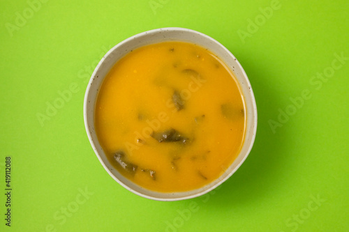 vegetable soup with spinach in the bowl on green background