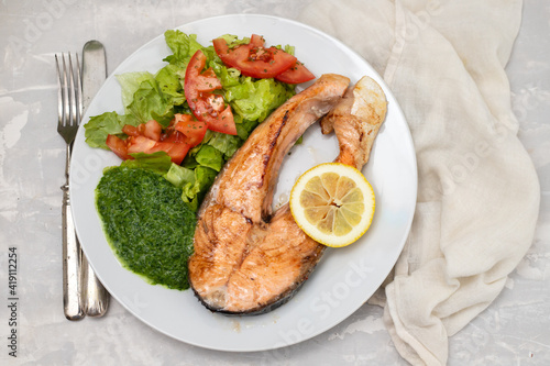 fried salmon with spinach and salad on white plate