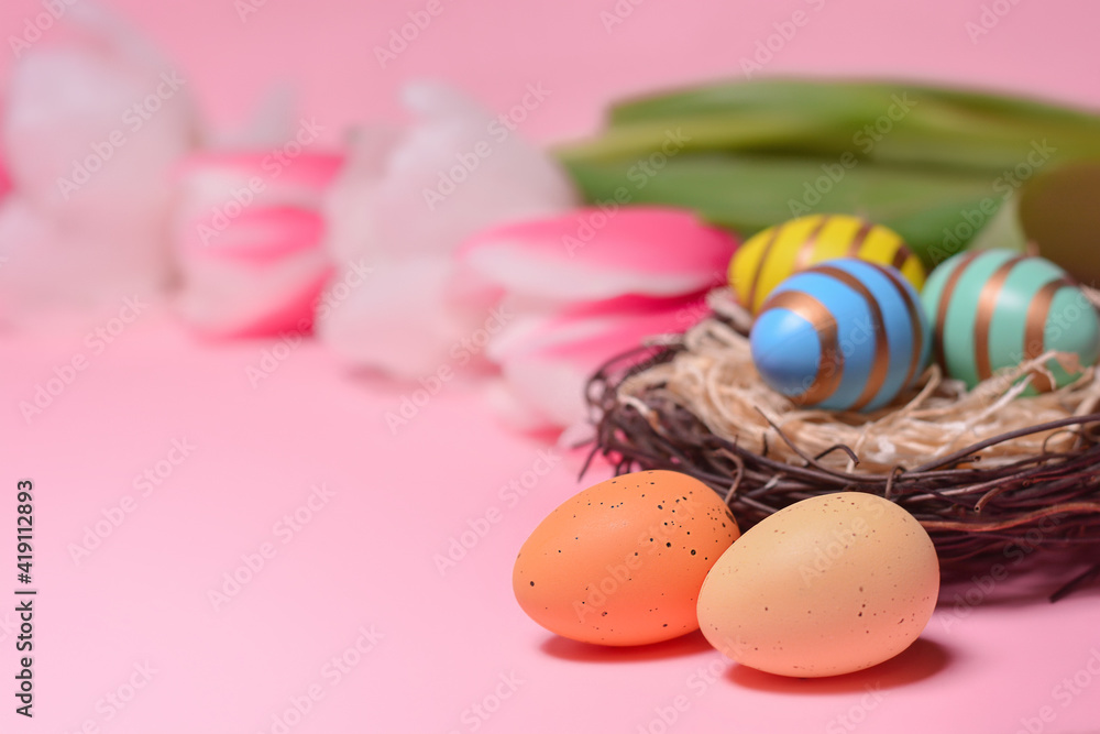 Easter eggs in a nest on a background of tulips. Holiday concept. Easter card.Copy space for text Easter eggs in a nest on a background of tulips. Holiday concept. Easter card.Copy space for text