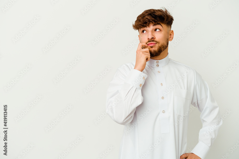 Young Moroccan man wearing a typical arab clothes isolated on white background looking sideways with doubtful and skeptical expression. Young Moroccan man wearing a typical arab clothes isolated on white background looking sideways with doubtful and skeptical expression.