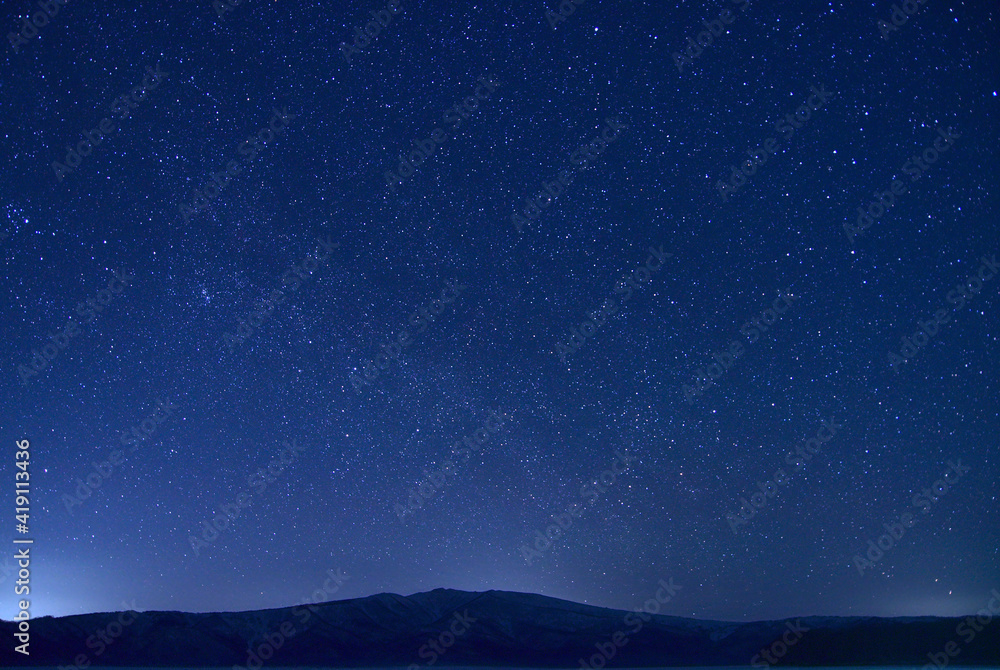 Fototapeta premium 山のシルエットと満天の星空。