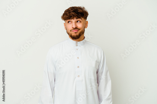 Young Moroccan man wearing a typical arab clothes isolated on white background confused, feels doubtful and unsure. © Asier