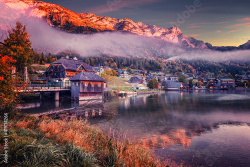 Wonderful Autumn Sunny Morning over the alpine lake. Majestic Mountains with fog, reflected in Water. Beauty in nature. Amazing Autumn landscape, Grundlsee, Styria, Austria. Colorful nature scenery.