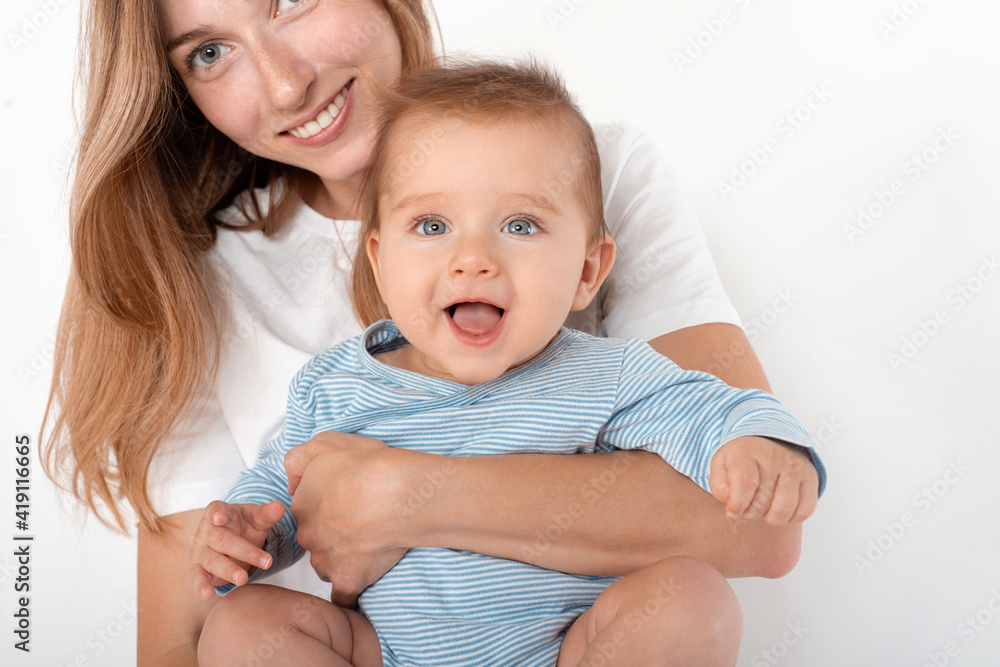 Mother holding cute happy baby boy with beautiful blue eyes on white background Mother holding cute happy baby boy with beautiful blue eyes on white background