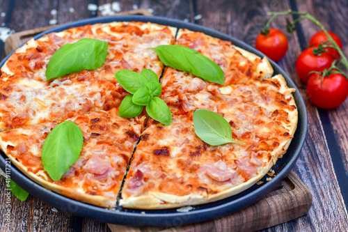  Close up of hot italian pizza classic ham. Fresh basil,tomato sauce ,mozzarella cheese , mushrooms and minced meat .Concept poster for Restaurants or pizzerias. Top view