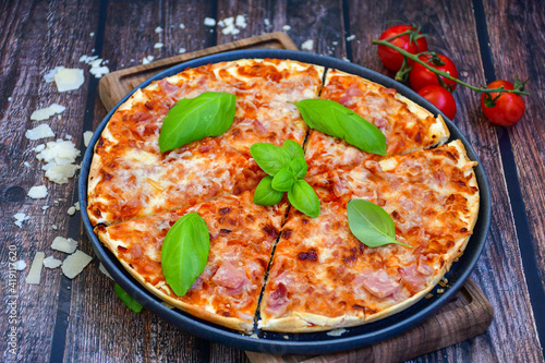  Close up of hot italian pizza classic ham. Fresh basil,tomato sauce ,mozzarella cheese , mushrooms and minced meat .Concept poster for Restaurants or pizzerias. Top view