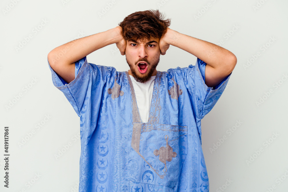 Young Moroccan man isolated on white background screaming with rage. Young Moroccan man isolated on white background screaming with rage.