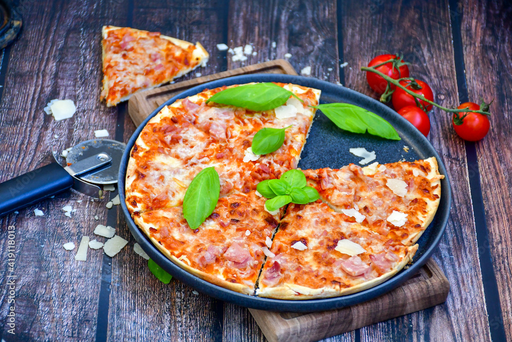 Close up of hot italian pizza classic ham. Fresh basil,tomato sauce ,mozzarella cheese , mushrooms and minced meat .Concept poster for Restaurants or pizzerias. Top view Close up of hot italian pizza classic ham. Fresh basil,tomato sauce ,mozzarella cheese , mushrooms and minced meat .Concept poster for Restaurants or pizzerias. Top view