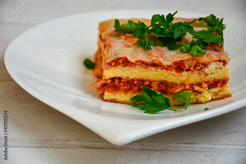  Delicious Home made keto diet Lasagna bolognese with Lupin Flour, minced meat,tomato sauce and spinach on a wooden rustic background.Home made low carb italian meal