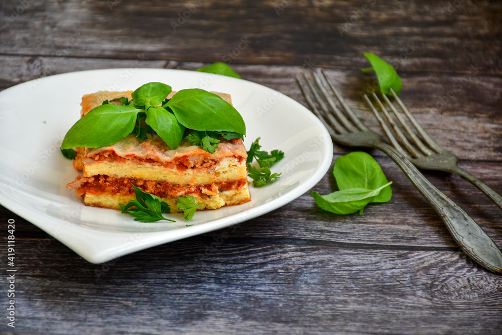   Delicious Home made keto diet  Lasagna bolognese  with  Lupin Flour, minced meat,tomato sauce and spinach  on a wooden rustic  background.Home made low carb italian meal
