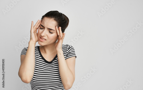 woman in t-shirt holding her head discontent health problem