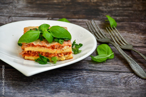   Delicious Home made keto diet  Lasagna bolognese  with  Lupin Flour  minced meat tomato sauce and spinach  on a wooden rustic  background.Home made low carb italian meal