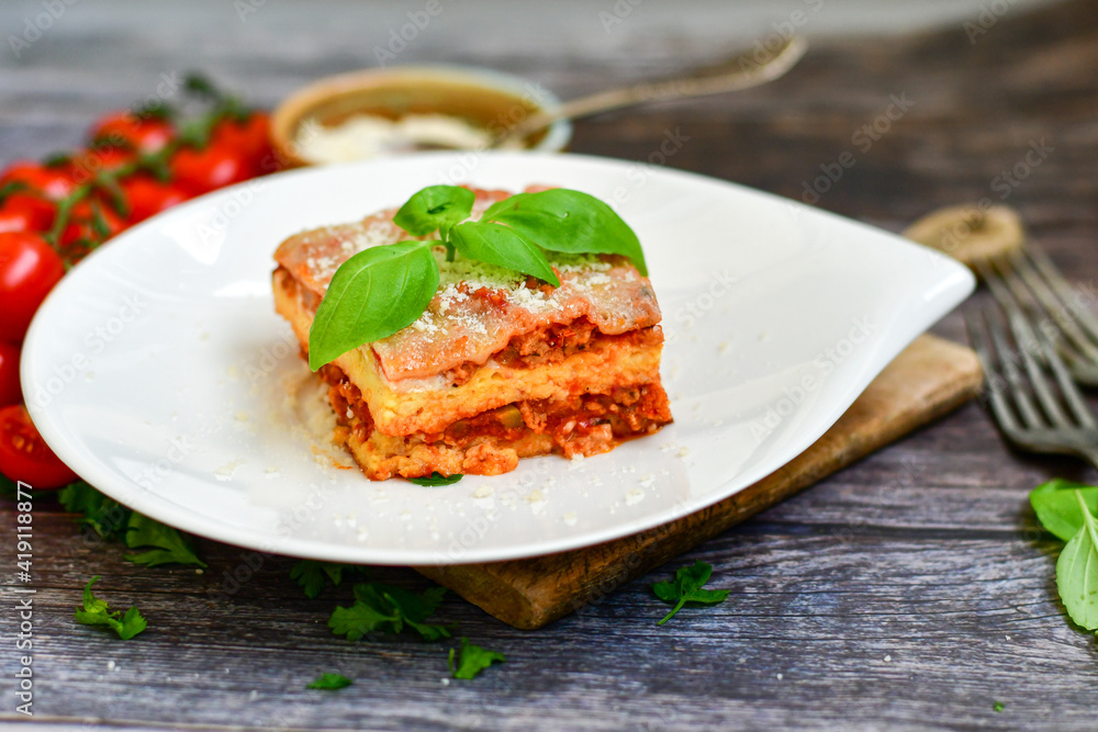Delicious Home made keto diet Lasagna bolognese with Lupin Flour, minced meat,tomato sauce and spinach on a wooden rustic background.Home made low carb italian meal Delicious Home made keto diet Lasagna bolognese with Lupin Flour, minced meat,tomato sauce and spinach on a wooden rustic background.Home made low carb italian meal