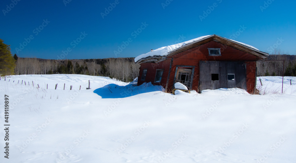 Very old garage in a field during Quebec winter in Canada