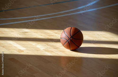 Basketball on hardwood court floor with natural lighting. Workout online concept © Augustas Cetkauskas