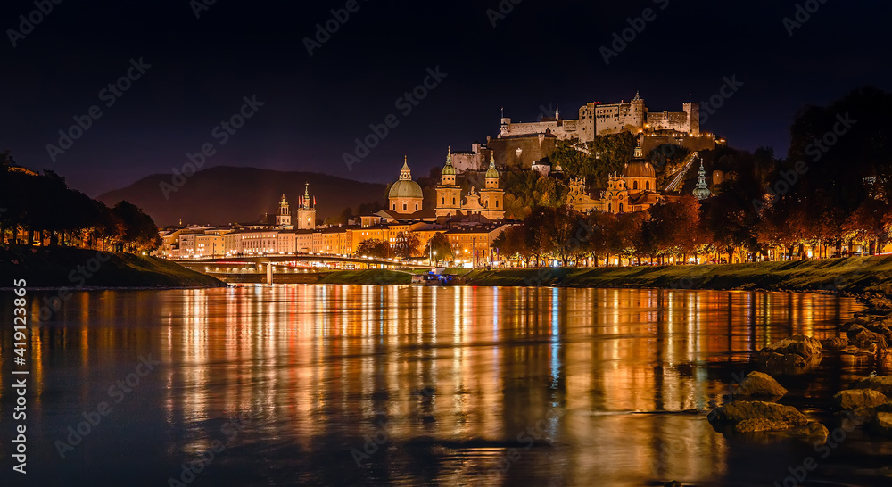 Obraz premium Fantastic colorful evening view on Salzburg historical city. Castle Hohensalzburg with night street light and perfect reflection. concept ideal resting place. Popular travel and historical center.