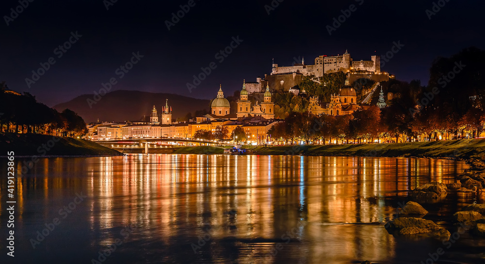 Fantastic colorful evening view on Salzburg historical city. Castle Hohensalzburg with night street light and perfect reflection. concept ideal resting place. Popular travel and historical center.
