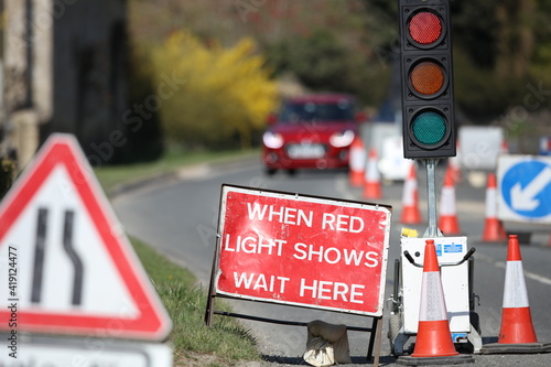 Country lane road work temporary traffic lights and signs