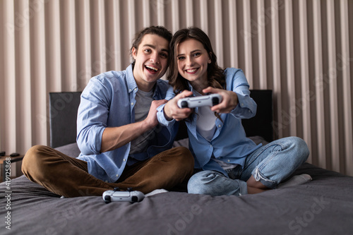 Young cheerful couple play to video game on a couch