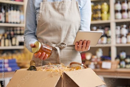 Εκτύπωση καμβά Close Up Of Female Owner Of Delicatessen Food Shop With Digital Tablet Preparing