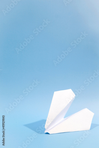 White paper airplane with shadow. Airplane on a blue background