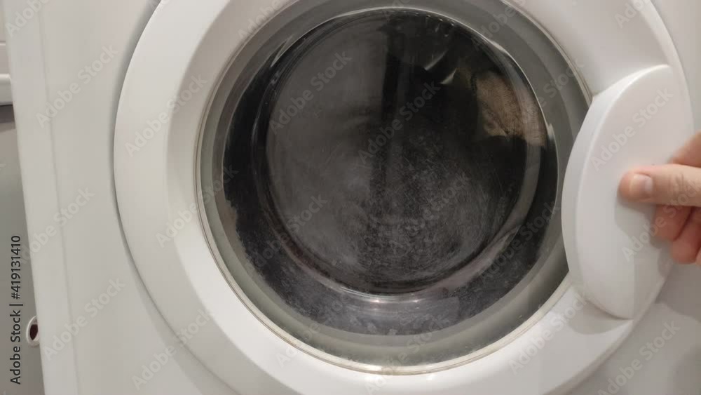 Housekeeper loading dirty laundry into the washing machine Housekeeper loading dirty laundry into the washing machine