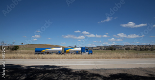 Truck on a freeway in an Australian Country Town midway between Sydney and Melbourne with nice blue sky and lush green trees as a backdrop