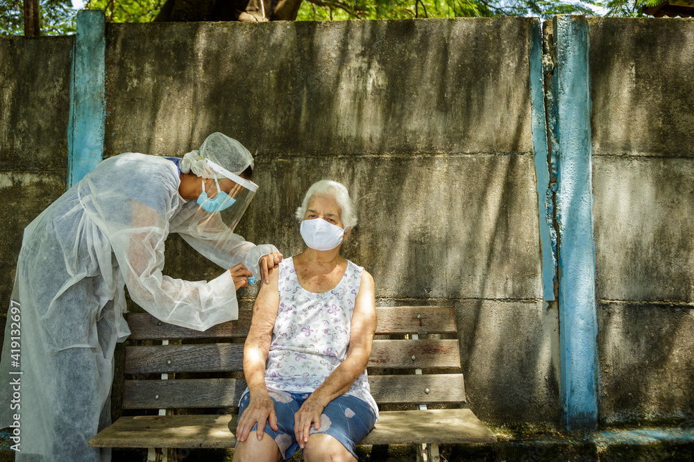 Idosa recebe vacina contra Covid em área rural de Guarani, estado de Minas Gerais, Brasil