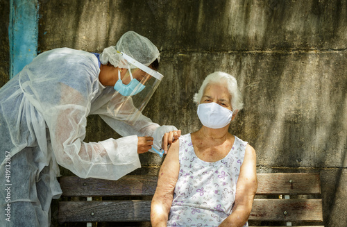 Idosa recebe vacina contra Covid em área rural de Guarani, estado de Minas Gerais, Brasil photo