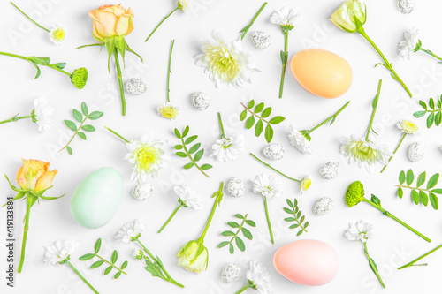 Creative layout composition of flowers and easter eggs on pastel background.