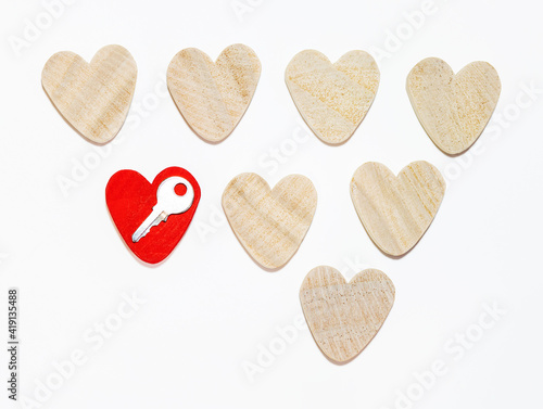 eight wooden hearts, one red. rows. isolated. concept of the key to the heart