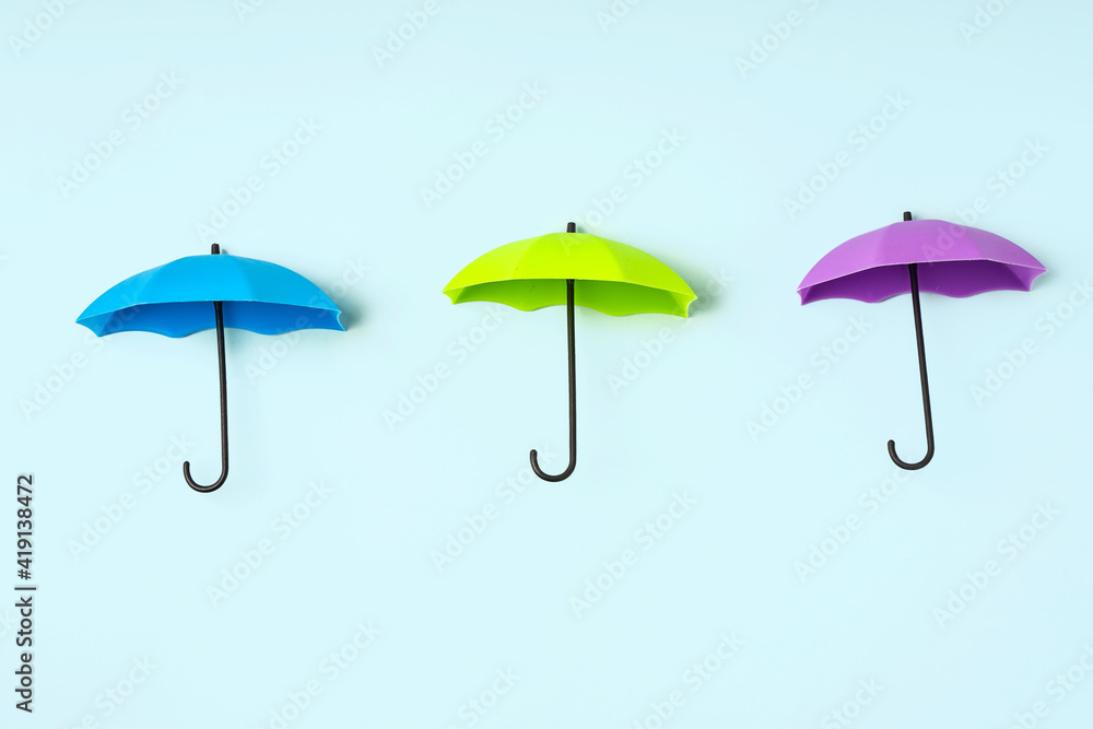 Colored umbrellas on a blue background. Conceptuality and place for the text