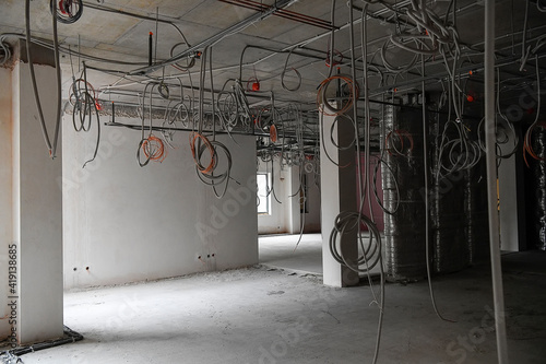 Interior of office or industrial premises under construction. Placement of electrical wires and cables.
