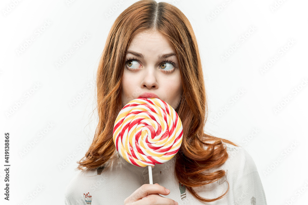 pretty red-haired woman with multicolored lollipop near face cropped view of sweets emotions