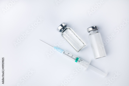 Syringe injection, vaccine vial and medicine drug bottles and on a white background. Vaccination, immunization, treatment to Covid-19. Close-up. Copy space.