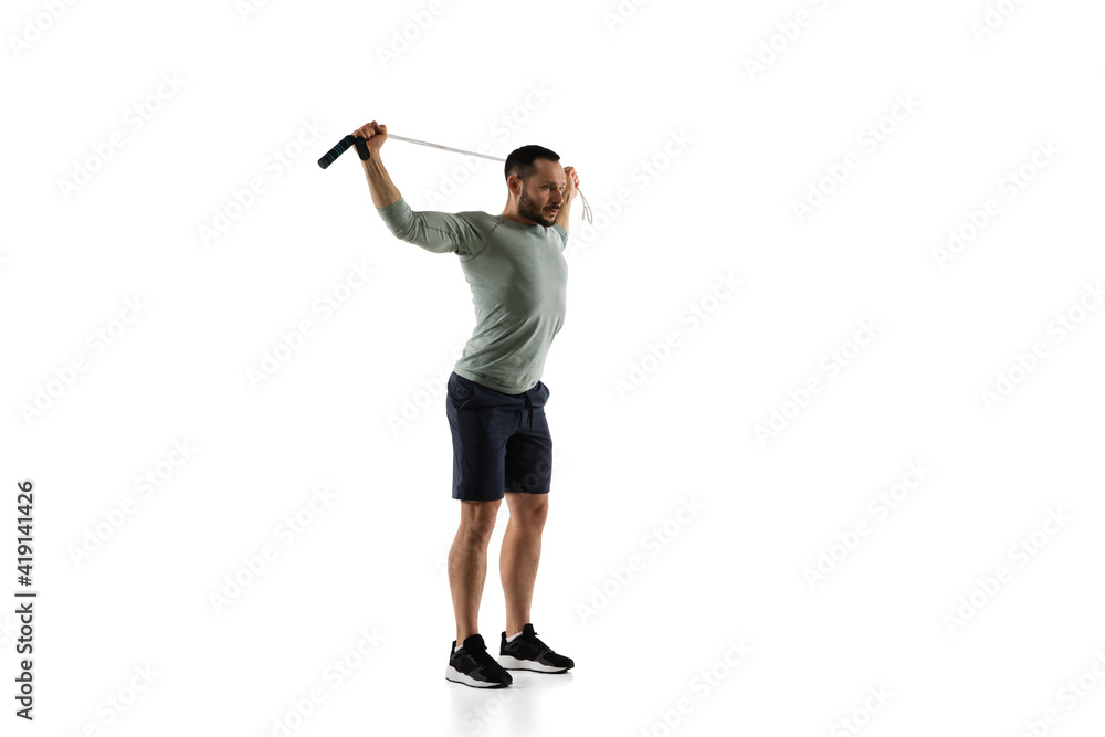 Jumping-rope. Young caucasian male model in action, motion on white background with copyspace. Concept of sport, movement, energy and dynamic, healthy lifestyle. Training, practicing. Authentic. Jumping-rope. Young caucasian male model in action, motion on white background with copyspace. Concept of sport, movement, energy and dynamic, healthy lifestyle. Training, practicing. Authentic.